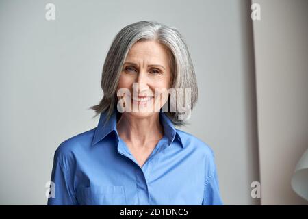 Lächelnd anspruchsvolle reifen grauhaarige Frau Kopfschuss Porträt. Stockfoto