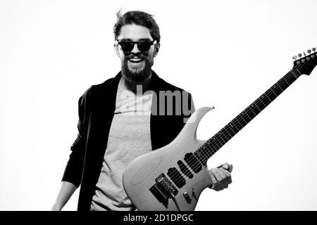 Ein Mann mit einer Gitarre Emotionen Musik Spiel Performance Leder Jacke Sonnenbrille Licht Hintergrund Stockfoto