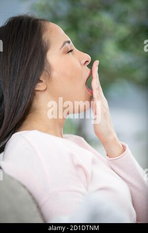 Frau Gähnen auf weißem Hintergrund Stockfoto