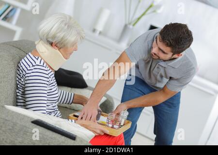 Helfer im Dienst ältere Frau mit Mahlzeit in Pflege zu Hause Stockfoto