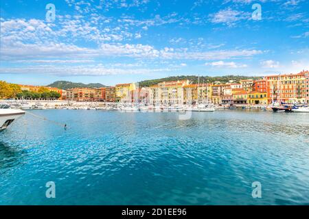 Boote im Jachthafen und Cafés und Geschäfte entlang des Meeres am bunten alten Hafen der Mittelmeerstadt Nizza, Frankreich, entlang der französischen Riviera. Stockfoto