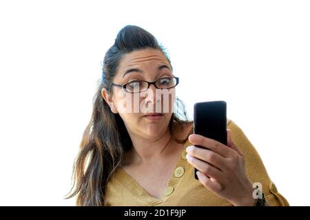 Eine junge Frau erscheint schockiert, als sie einen anschaut Bild auf ihrem Handy Stockfoto