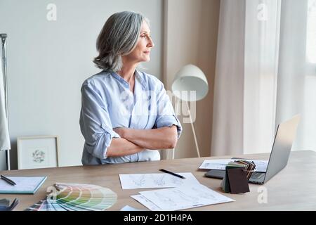 Stilvolle elegante reife Frau Modedesignerin Denken auf neue kreative Ideen. Stockfoto