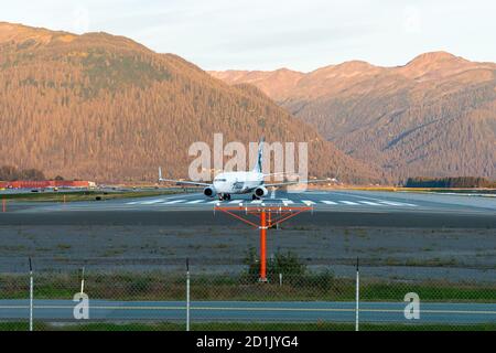 Alaska Airlines Boeing 737 auf der Landebahn des Juneau International Airport mit Berg dahinter. Luftverkehr in Alaska Stockfoto