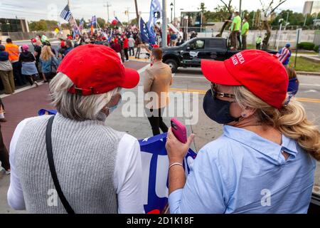 Bethesda, MD, USA, 5. Oktober 2020. Im Bild: Zwei Frauen tragen Make America Great Again Hüte halten eine Trump 2020 Flagge, um ihre Unterstützung für den Präsidenten zu zeigen, als seine Anhänger vor Walter Reed National Military Medical Center versammelten, wo er für covid-19 ins Krankenhaus eingeliefert wurde. Fans des Präsidenten kamen, um ihre Unterstützung während der vier Tage zu zeigen, die er im Krankenhaus blieb, nachdem er sich mit dem neuartigen Coronavirus infiziert hatte. Kredit: Allison C Bailey/Alamy Live Nachrichten Stockfoto