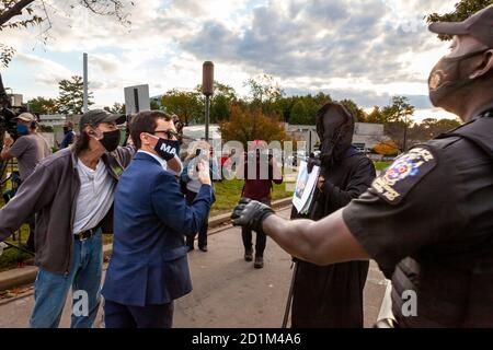 Bethesda, MD, USA, 5. Oktober 2020. Im Bild: Ein Montgomery County Maryland Polizeibeamter tritt ein, um die schnell eskalierende verbale und physische Aggression von Trump-Unteroffizierern gegen einen Mann zu stoppen, der als der Sensenmann verkleidet ist. Trump-Anhänger versammelten sich vor dem Walter Reed National Military Medical Center, wo der Präsident wegen Covid-19 nach einer Infektion mit dem neuartigen Coronavirus ins Krankenhaus eingeliefert wurde. Kredit: Allison C Bailey/Alamy Live Nachrichten Stockfoto