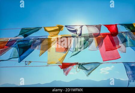 Bunte buddhistische Gebetsflaggen, die im Wind wehen Stockfoto