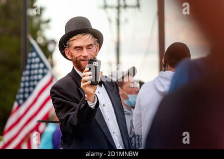 Bethesda, MD, USA, 5. Oktober 2020. Im Bild: Ein Trump-Anhänger, der als Abraham Lincoln gekleidet war, machte Fotos mit seinem Telefon, während er außerhalb des Walter Reed National Military Medical Center war, wo der Präsident wegen Covid-19 ins Krankenhaus eingeliefert wurde, nachdem er sich an dem neuartigen Coronavirus angekleidet hatte. Eine Reihe von Trump-Anhängern versammelten sich vor dem Eingang des Zentrums für die vier Tage, die er im Krankenhaus war. Kredit: Allison C Bailey/Alamy Live Nachrichten Stockfoto