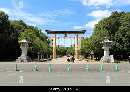 Japanische Familie, die vor dem Eingang torii Tor des Kashihara Jingu Temple fotografiert. Aufgenommen im September 2019. Stockfoto