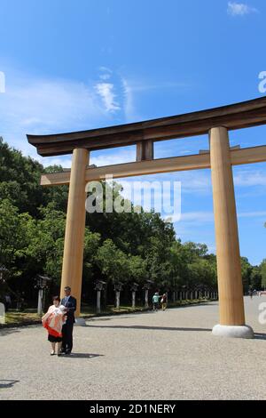 Japanische Familie, die vor dem Eingang torii Tor des Kashihara Jingu Temple fotografiert. Aufgenommen im September 2019. Stockfoto