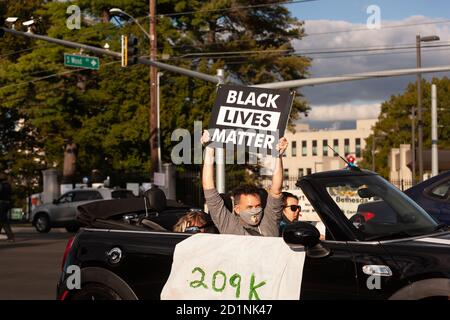 Bethesda, MD, USA, 5. Oktober 2020. Im Bild: Anhänger von Black Lives Matter mit einem BLM-Zeichen und einem Hinweis auf die 2009,000 durch das Coronavirus getöteten Amerikaner, die von der Pro-Trump-Menschenmenge getrieben wurden, versammelten sich vor dem Walter Reed National Military Medical Center, wo der Präsident nach der Ansteckung mit dem neuartigen Coronavirus für Covid-19 ins Krankenhaus eingeliefert wurde. Kredit: Allison C Bailey/Alamy Live Nachrichten Stockfoto