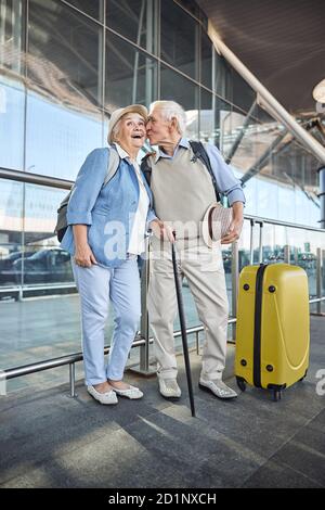 Männlich Ehepartner küssen seine lächelnde Frau auf der Wange Stockfoto