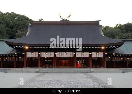 Miko oder Priesterin des Kashihara Jingu Tempels, beleuchtet von Laternen in Nara, Japan. Aufgenommen im September 2019. Stockfoto