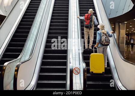 Zwei ältere Touristen benutzen die bewegliche Treppe Stockfoto