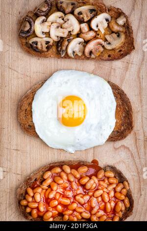 Eier, Pilze und Bohnen auf Toast mit Sauerteig Brot Stockfoto