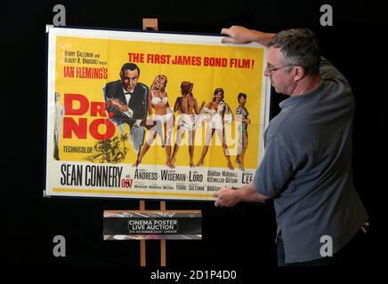 Ein Mitarbeiter von Prop Store passt ein britisches Quadposter für den James Bond-Film 'DR No' (Schätzung: £8-10.000) aus dem Jahr 1962 während einer Vorschau auf die bevorstehende Kinoposterauktion des Prop Store in Chorleywood, Hertfordshire, an. Stockfoto