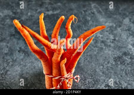 Hässliches Essen. Deformierte organische Karotten auf blauem Hintergrund. Deformierte Produkte, Problemkonzept für Lebensmittelabfälle. Stockfoto