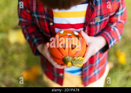 Kinder Hand hält Jack'O Kürbis Lampe, Trick or Treat an Halloween Tag. Konzept für Herbstferien Hintergrund. Stockfoto