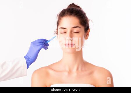 Studioaufnahme der schönen Frau während der Gesichtsverjüngung Verfahren. Anti-Aging-Injektion für Gesichtshaut isoliert auf weißem Hintergrund. Stockfoto