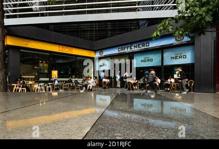 Menschen sitzen vor einem Caffe Nero und Leon Lebensmitteleinzelhandel Kettencafé im Zentrum von London Stockfoto