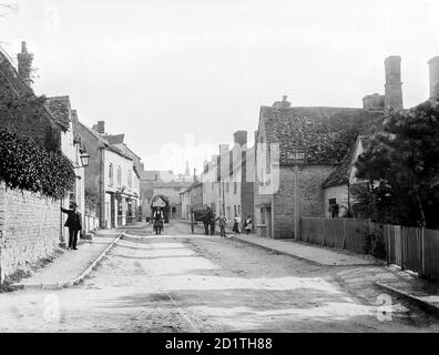 CHARLBURY, Oxfordshire. Eine Straßenszene, die die Thames Street mit mehreren Einwohnern zeigt, einer mit einer Schubkarre, die in der Nähe des öffentlichen Hauses Talbot steht. Fotografiert von Henry Taunt (aktiv 1860 - 1922). Stockfoto