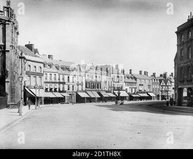 CIRENCESTER, Gloucestershire. Blick auf den Marktplatz von der Pfarrkirche der Hauptstadt der Cotswolds. Zeigt die Ladenfronten auf der Nordseite mit ihren Markisen über dem Bürgersteig. Fotografiert 1883 von Henry Taunt. Stockfoto