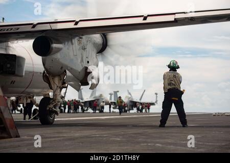 Der Flugmaschinist Mate Airman Isaiah Koschnitzke aus Port Heron, Michigan, führt Endkontrollen an einem E-2D Hawkeye durch, der an den Tigertails von Airborne Command & Control Squadron (VAW) 125 befestigt ist, bevor er vom Flugdeck des einzigen vorwärts eingesetzten Flugzeugträgers der Marine USS Ronald Reagan (CVN 76) gestartet wird. Ronald Reagan, das Flaggschiff der Carrier Strike Group 5, bietet eine kampfbereite Kraft, die die Vereinigten Staaten schützt und verteidigt, sowie die kollektiven maritimen Interessen ihrer Verbündeten und Partner im Indo-Pazifik. (USA Navy Foto von Mass Communication Specialist 2. CLA Stockfoto