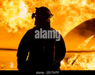 Ein Feuerwehrmann aus dem 436. Bauingenieursgeschwader überwacht nachts am 28. September 2020 auf der Dover Air Force Base, Delaware, eine Live-Feuerbrandübung. Total Force und Zivilfeuerwehr Unternehmen in der umliegenden Gemeinde oft Partner mit Dover AFB, um die jährlichen Ausbildungsanforderungen zu erfüllen. (USA Luftwaffe Foto von Senior Airman Christopher Quail) Stockfoto