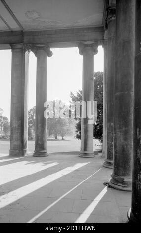 PITTVILLE PUMPENRAUM, Pittville Park, Cheltenham, Gloucestershire. Cheltenham entwickelte sich als Kurort im späten 18. Und frühen 19. Jahrhundert. Der Pittville Pump Room wurde 1825-30 als Business Venture für Joseph Pitt gebaut. Vom neo-griechischen Kolonnadeneingang zu den Pump Rooms aus kann man die gepflegten Gärten bewundern. Fotografiert von Eric de Mare zwischen 1945 und 1980. Stockfoto