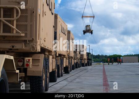 201004-N-ER806-1066 APRA HARBOUR, Guam (Okt 4, 2020) Matrosen der Task Group 75.2 nutzen ihre Frachtumschlagsfähigkeiten, um US-Armeefahrzeuge auf das Roll-on/Roll-off-Frachtschiff M/V Cape Hudson (T-AKR 5066) auf dem Marinestützpunkt Guam zu laden. Die Task Force 75 ist die primäre Expeditions-Task Force der 7. Flotte und ist für die Planung und Ausführung von maritimen Sicherheitsoperationen, der Entsorgung von Sprengkörpern, dem Tauchen, dem Engineering und dem Bau sowie dem Unterwasserbau in der gesamten Indo-Pazifik-Region verantwortlich. (USA Navy Foto von Mass Communication Specialist 2nd Class Nick Bauer) Stockfoto