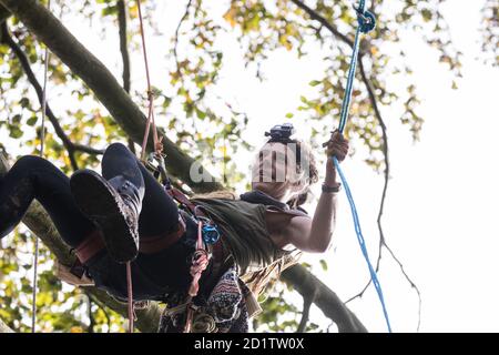 Aylesbury Vale, Großbritannien. Oktober 2020. Ein Baumschützer klettert auf ein Baumhaus etwa 60 Meter über dem Boden in einem Wildschutzlager in alten Wäldern am JonesÕ Hill Wood. Das Camp JonesÕ Hill Wood, eines von mehreren Protestcamps, das von Anti-HS2-Aktivisten entlang der Strecke der 106 Mrd. £schweren HS2-Hochgeschwindigkeitsstrecke errichtet wurde, um dem umstrittenen Infrastrukturprojekt zu widerstehen, wird derzeit von den Gerichtsvollziehern des National Evction Teams, die im Auftrag der HS2 Ltd. Arbeiten, vertrieben. Quelle: Mark Kerrison/Alamy Live News Stockfoto