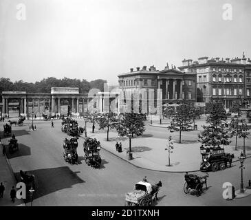 HYDE PARK ECKE, Westminster, London. Blick nach Norden in Richtung Hyde Park Corner Screen (von Decimus Burton) und Apsley House (heute Wellington Museum). Apsley House wird als das letzte in einer Reihe von Gebäuden auf Piccadilly gezeigt - seine Nachbarn sind nun verschwunden. Der gesamte Verkehr ist von Pferden gezogen und umfasst Busse und Wagen. Fotografiert um 1900 und Carl Norman zugeschrieben. Stockfoto