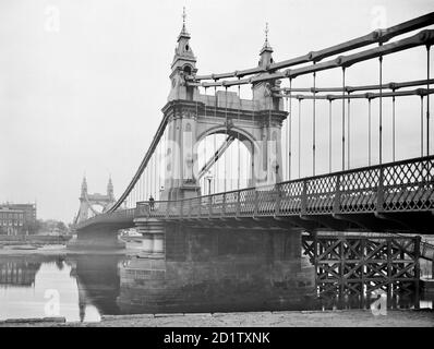 HAMMERSMITH BRIDGE, Barnes, Greater London. Diese dekorative Hängebrücke ist hier vom Ufer aus zu sehen. Es wurde 1887 von Sir Joseph Bazalgette, dem angesehenen Bauingenieur, der auch für das Londoner Abwassersystem sowie eine Reihe anderer Brücken verantwortlich war, erbaut. Fotografiert von Henry Taunt im Jahr 1895. Stockfoto