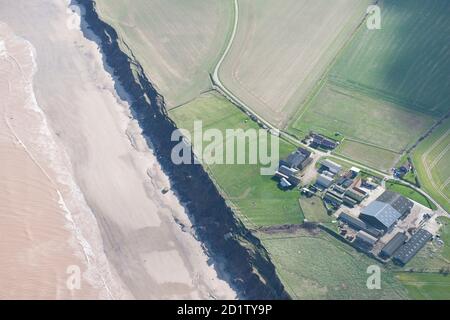 Grat und Furche Erdarbeiten auf niedrigen Bauernhof und Anzeichen von Küstenerosion mit Kollaps Pillbox am Strand und zweiten Weltkrieg Maschinenraum (Generatorhaus) rutscht die Klippe hinunter, Aldbrough Sands, East Riding of Yorkshire, 2014, UK. Luftaufnahme. Stockfoto