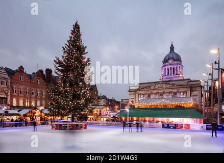 Allgemeiner Blick auf den Old Market Square von Süd-West während einer "Winter Wonderland" Veranstaltung, mit einem beleuchteten Weihnachtsbaum auf einer temporären Eisbahn im Vordergrund, und das Council House dahinter, Nottingham, Großbritannien. Stockfoto