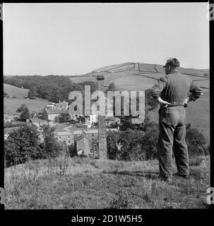 Ein Mann in einem Kesselanzug, der am Hang südwestlich von Dale End Mill, Lothersdale, Craven, North Yorkshire, Großbritannien, steht. Stockfoto