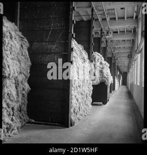 Eine mit Rohwolle gestapelte Bucht wartet auf die Verarbeitung in Salt's Mill, Victoria Road, Saltaire, Shipley, Bradford, West Yorkshire, Großbritannien. Stockfoto