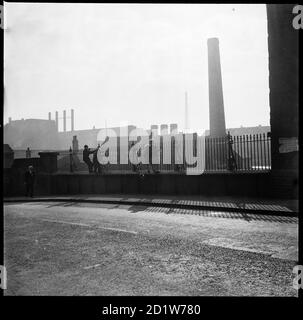 Eine Gruppe von Kindern, die George Goodwin und Sons' Westwood Mills von der Brücke, die die A50 (Lichfield Street) über den Caldon-Kanal, Hanley, Stoke-on-Trent, Staffordshire, Großbritannien, führt. Stockfoto