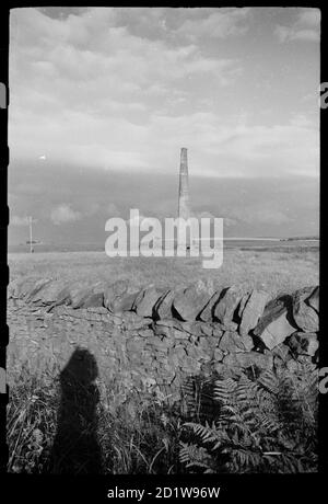 Blick auf einen einzigen Schornsteinschacht aus dem 19. Jahrhundert aus einer ehemaligen Bleischmelzmühle, von Norden aus gesehen auf der Hauptstraße, der B6305. Stockfoto