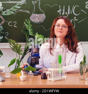 Nette Frau Lehrer mit Mikroskop in der Schule Klasse in Chemie-Unterricht. Durchführung wissenschaftlicher Forschung im Schülerlabor Stockfoto