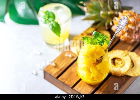 Hausgemachtes Ananas-Sorbet-Eis in einem Glas auf einem Holzhintergrund. Stockfoto