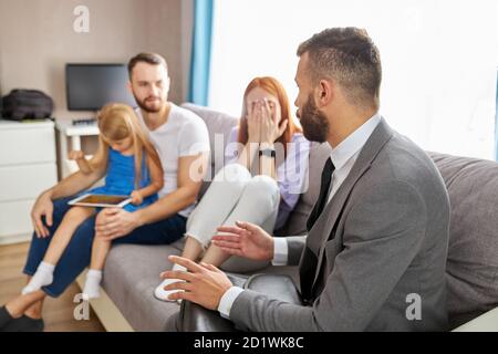 Junge kaukasische Familie expain Situation, Probleme der Familie Psychologe. Professionelle Therapeut aufmerksam auf sie hören, versuchen zu helfen, geben Ratschläge. Letzte Chance, die Familie zu retten Stockfoto