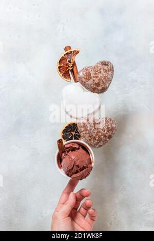 Wintereis mit Lebkuchengebäck. Lebkuchen und Eis fallen oder fliegen in Bewegung. Stockfoto