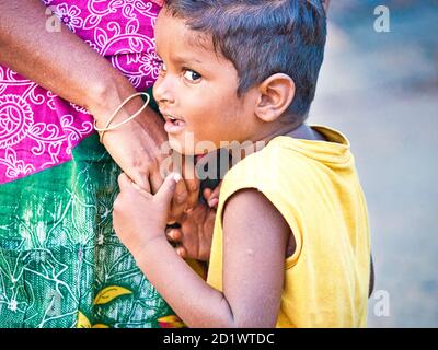 PUDUCHERRY, Indien - Dezember Circa, 2018. Nicht identifizierte schüchtern peinlich Sohn stand seine Mutter in die Straße, in der sich ein Dalit Dorf in der Nähe Stockfoto