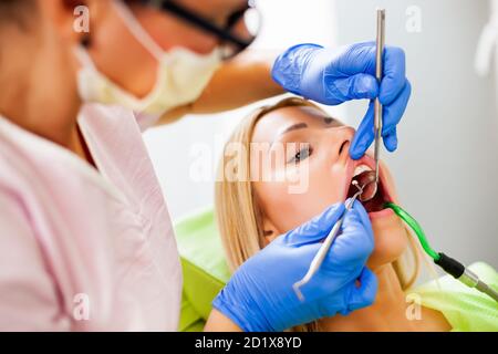 Junge Frau beim Zahnarzt. Zahnarzt besteht in der Reparatur der Zähne. Stockfoto