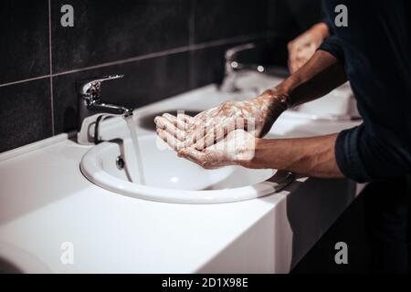 Nahaufnahme. Der Mensch wäscht sich vorsichtig die Hände mit Seife Stockfoto