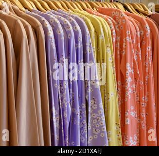 Nahaufnahme von hellen bunten Langarm-Shirts hängen von einem Regal in einem Geschäft Stockfoto