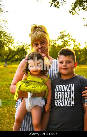 Großmutter mit ihren Enkeln. Enkelin und Enkel im Herbst oder Sommerpark. Familienporträt im Freien. Stockfoto