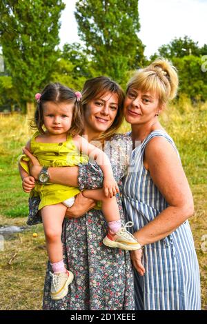 Großmutter, Mutter Und Tochter Entspannen Im Park. Drei Generationen spielen im Garten zusammen. Stockfoto