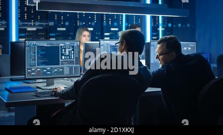 Team VON IT-Programmierern, die an Desktop-Computern im Kontrollraum des Rechenzentrums arbeiten. Team von Young Professionals arbeiten in Software und Hardware Stockfoto